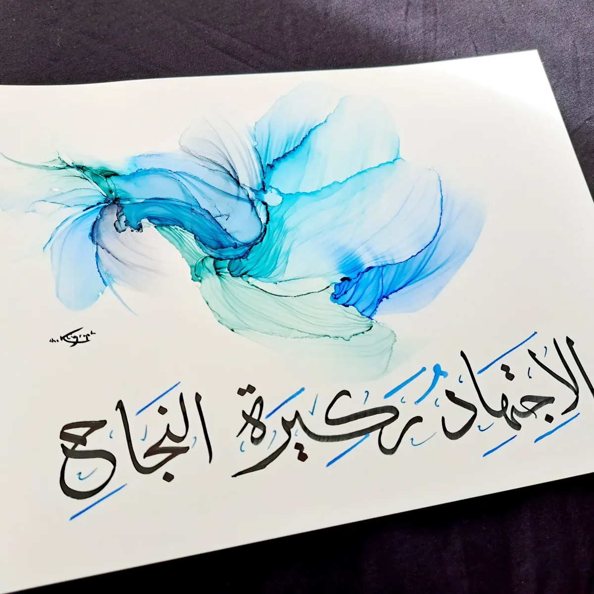 Calligraphie arabe noire sur une vague d'encre bleue